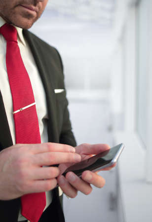 close up.businessman reading text message on smartphone