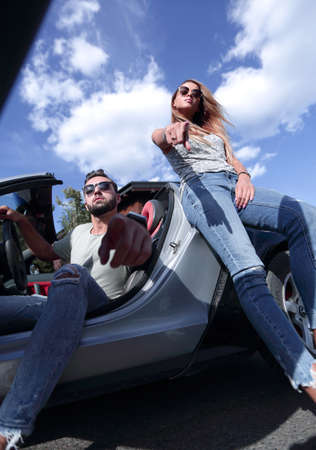 bottom view.modern young couple standing near the car.