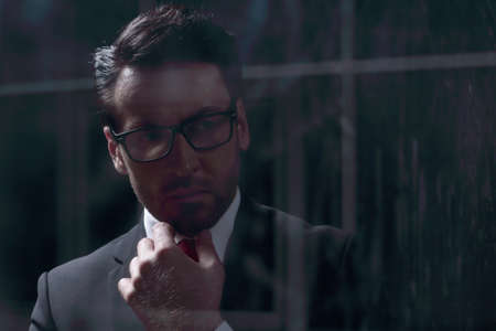close up.businessman standing in a dark office.