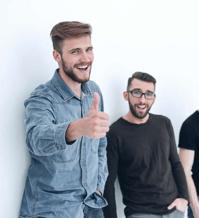 casual men next to the wall showing thumbs upの写真素材