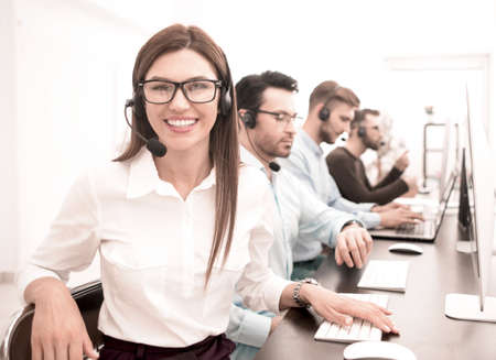 smiling call center employee works in a modern officeの写真素材
