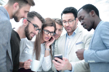 business team, looking carefully at the smartphone screenの写真素材