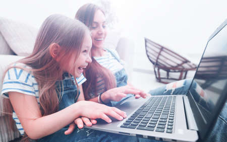 happy mother with adorable little girl with laptop