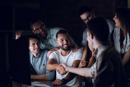 business colleagues shaking hands at the Deskの写真素材