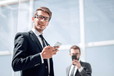 modern businessman with a smartphone on background officeの写真素材