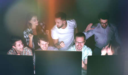 happy business team looking at computer screens