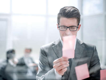 young employee reading a note on the glass.の写真素材
