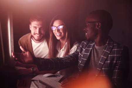 employees discussing something sitting at the Deskの写真素材