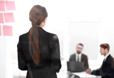rear view.young business woman standing in front of office Board.