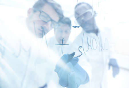 close up.a group of scientists recording the formula on a glassの写真素材
