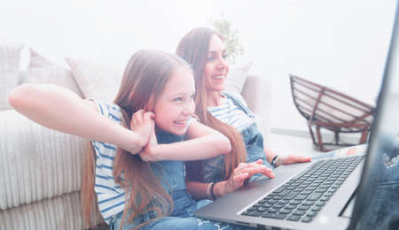 mother and daughter watch favorite TV showの写真素材