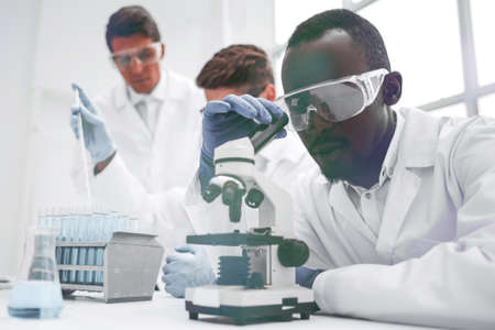 modern scientist looking through a microscopeの写真素材