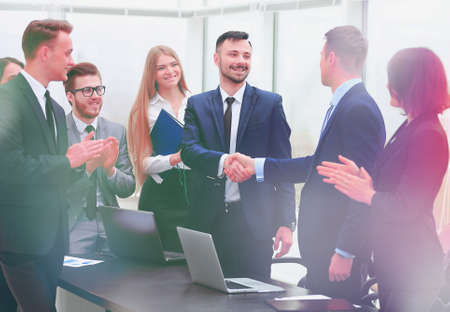 representatives of the two business teams greet each other