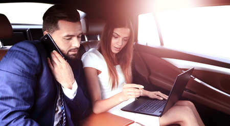 Confident businessman talking on the phone in car