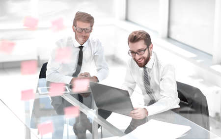 two happy employees reading a business document