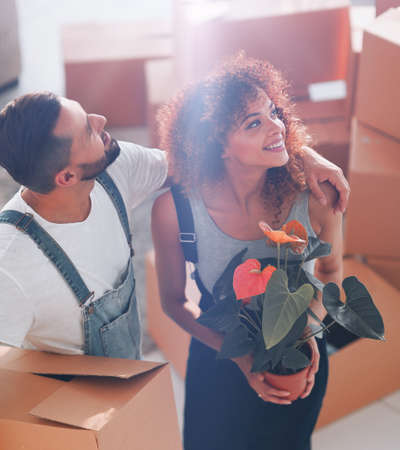 Beautiful young couple is carrying boxes to a new home.の写真素材