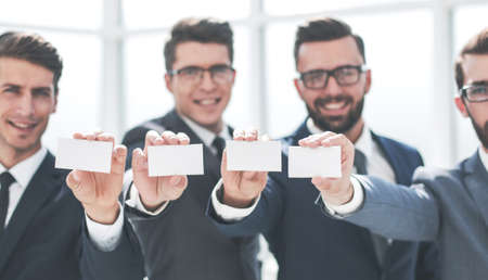 four young business people showing their business cardの写真素材