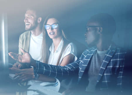 employees discussing something sitting at the Deskの写真素材