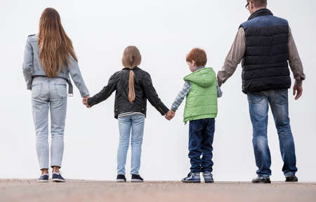 rear view of a happy family facing forward.の写真素材