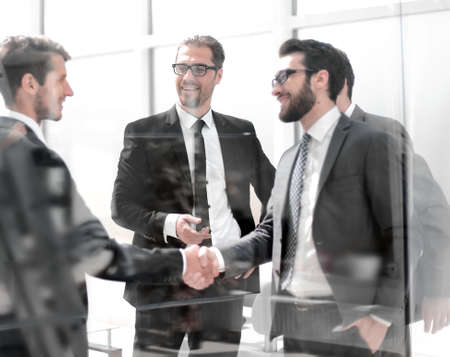 business partners shaking hands in the lobby of the business center
