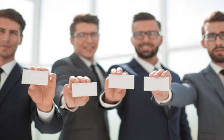 four young business people showing their business cardの写真素材