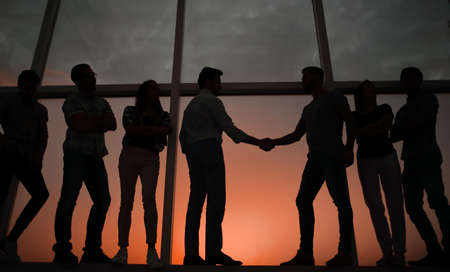 handshake of business partners on the background of the office windowの写真素材