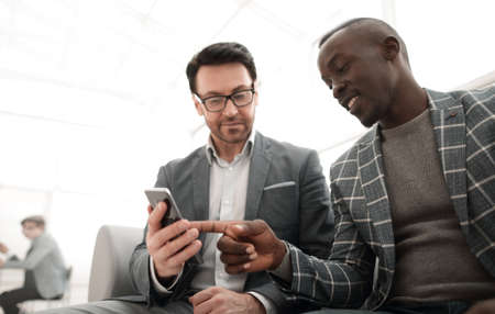 Two business people partners watching media content on a smartphone