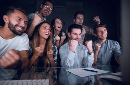 happy business team looking at computer monitor