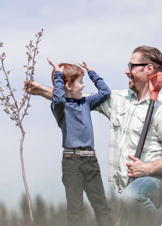 happy father and son plant a young tree