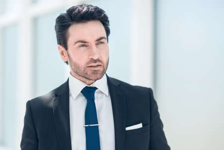serious businessman standing near an office window