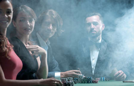 Upper class friends gambling in a casino.