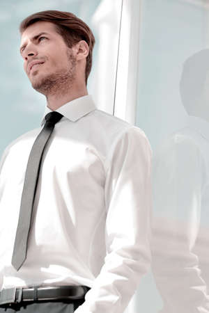 close up.successful businessman standing near the office window