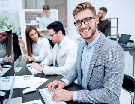 smiling businessman uses a computer to analyze financial dataの写真素材