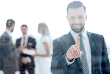 successful businessman pressing his finger on the glass screen