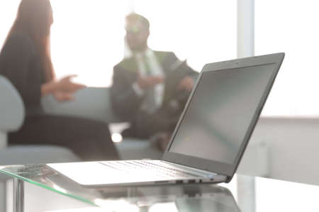 Focus on laptop on the table. Blurred people on background.の写真素材