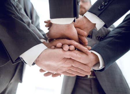 Close-up of businesspeople stacking hands in meeting