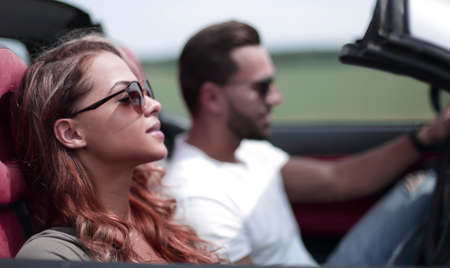 close up.a young woman with her boyfriend in a convertible car