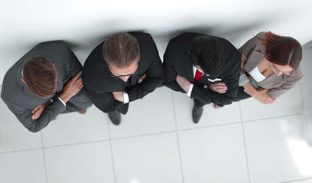 group of confident business people standing near the wall