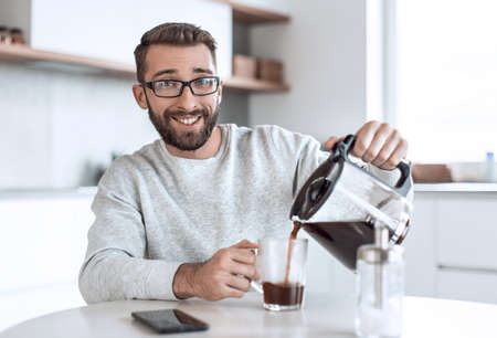 attractive man pouring himself a Cup of morning coffeeの写真素材