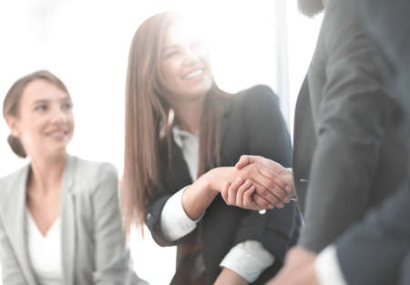 close up.smiling business woman shaking hands with partnersの写真素材