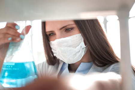 close up. woman doctor in protective mask with flaskの写真素材