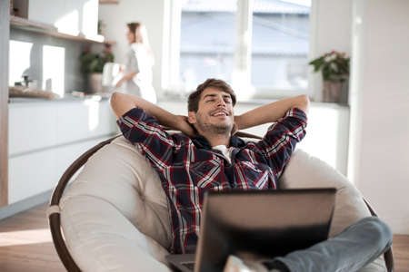 close up. tired guy dozing sitting in front of an open laptopの写真素材