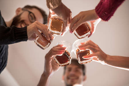 background image of a glass of juice in the hands of the young coupleの写真素材