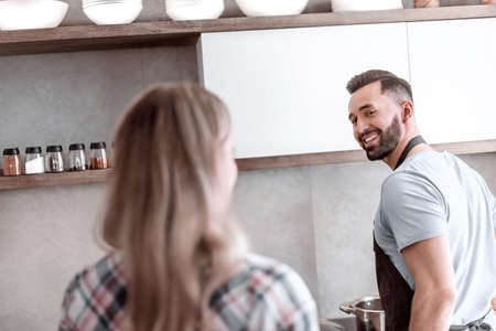 happy couple discussing the menu standing in the kitchenの写真素材