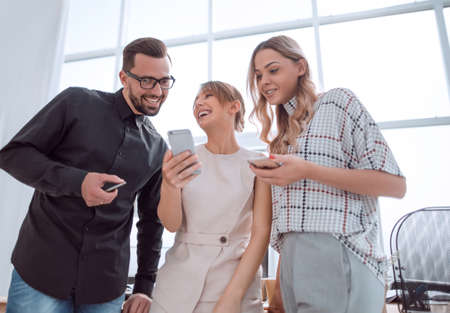 business team looking at the screens of their smartphonesの写真素材