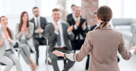 rear view. business woman makes a report for employeesの写真素材
