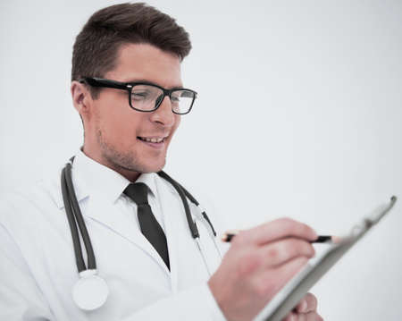 close up.smiling doctor writing a prescription.