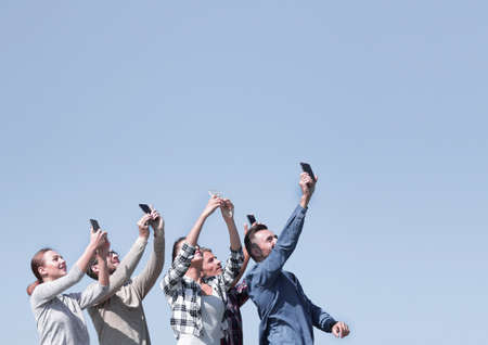 rear view. happy friends doing a selfie.の写真素材