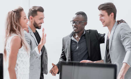colleagues giving each other a high five while standing in the officeの写真素材