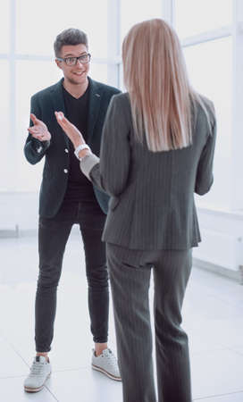 business people discussing something while standing in the officeの写真素材